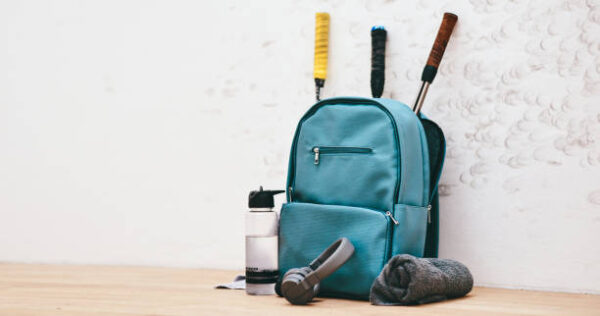 Shot of a sports bag and other items in an empty squash court